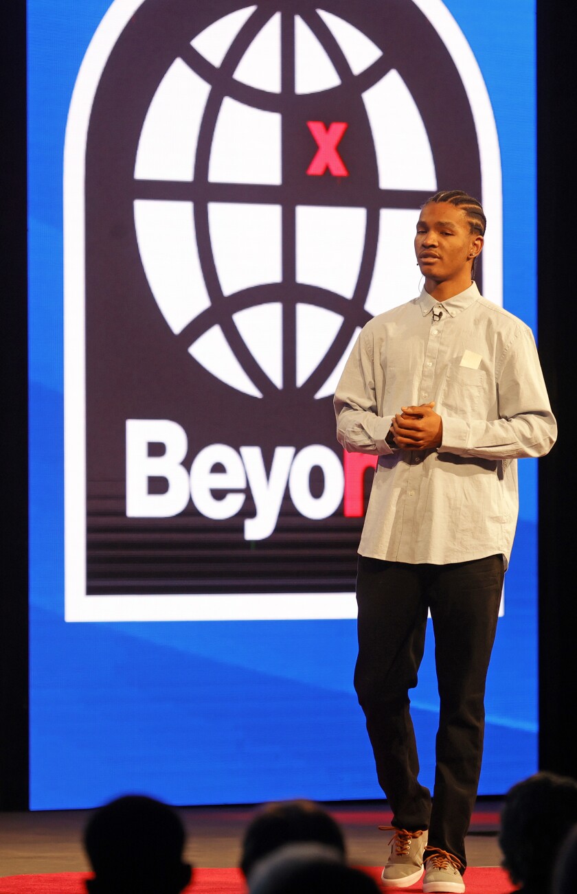 A man in a button down shirt speaks on a stage in front of a logo that reads "Beyond."
