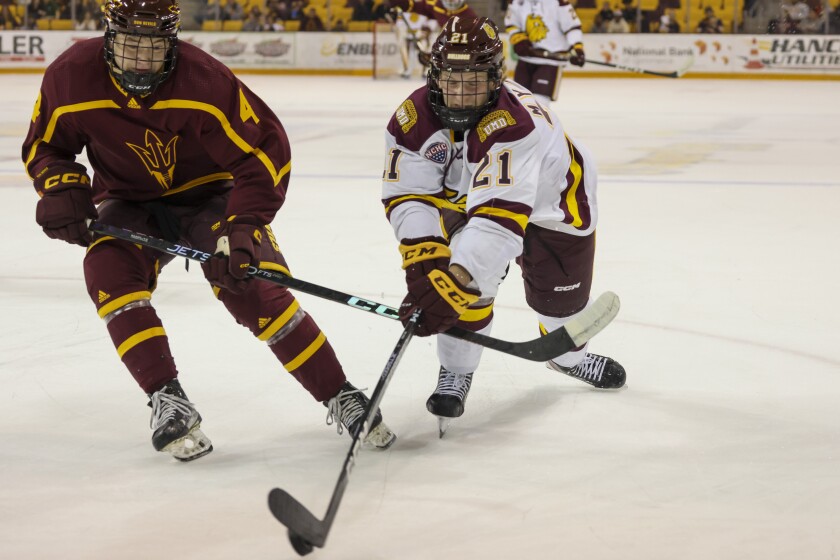 College hockey players play game in indoor arena