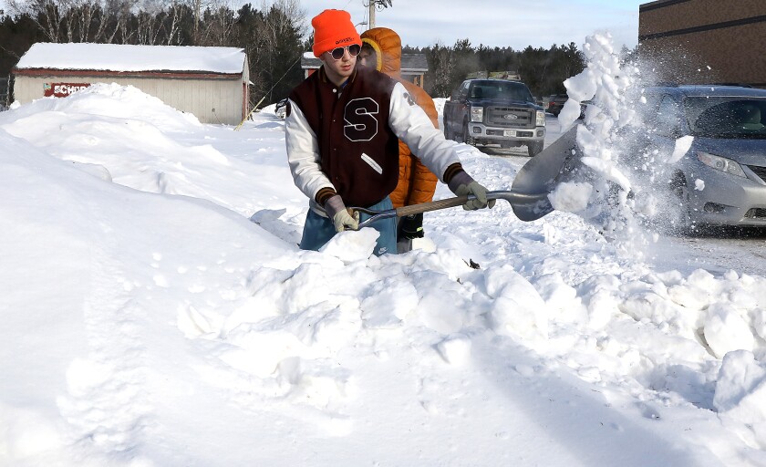Isaiah Kastern shovels snow from his shelter
