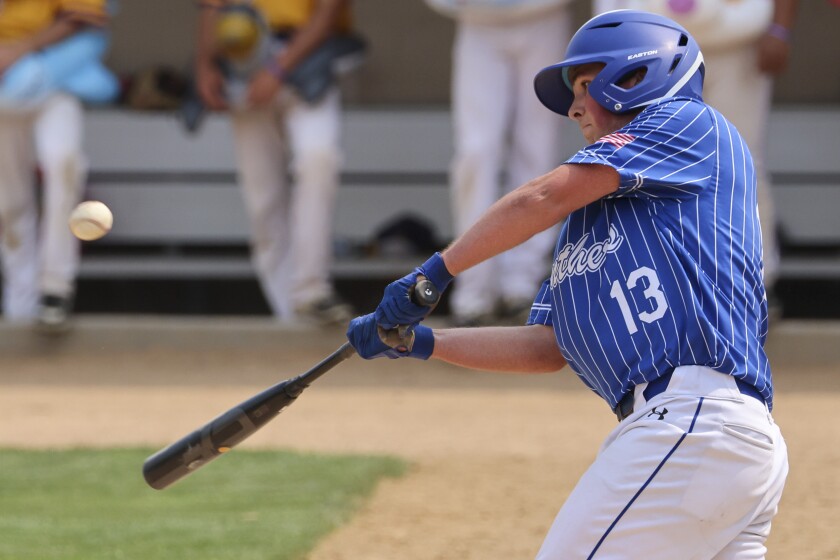 High school baseball players play on outdoor field on sunny day