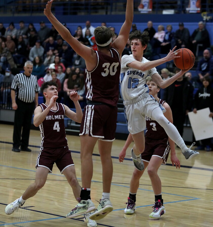 Superior’s Devon Ford (12) soars through the air as he passes around Holmen’s Drew Tengblad (30)