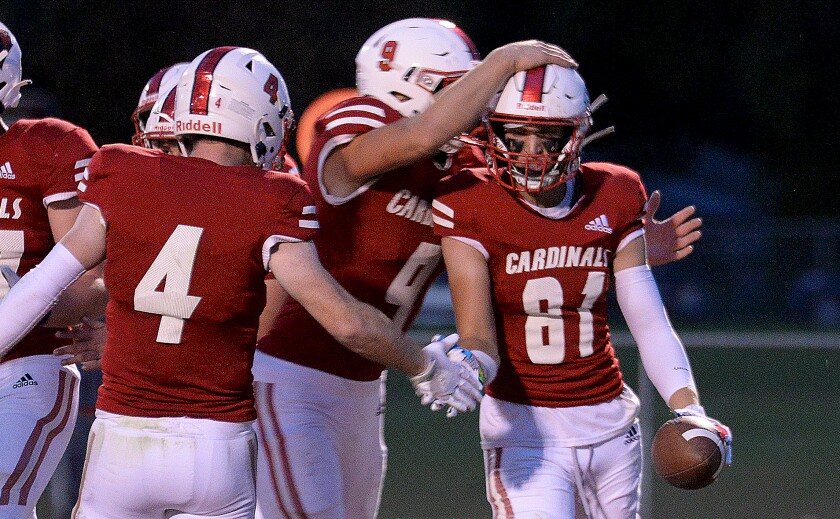 Willmar senior Sam Raitz, 81, is mobbed by teammates after scoring a touchdown in the first quarter during a North Central White District game against Delano on Friday, Sept. 30, 2022 at Hodapp Field.