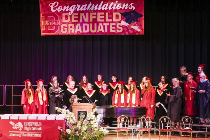 Students in maroon robes graduate