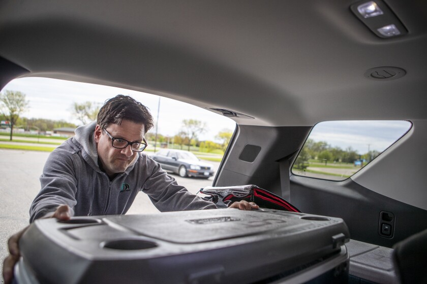 Mark Holtan of Central Community Transit loads coolers of food up before distributing them on Friday, May 20, 2022.