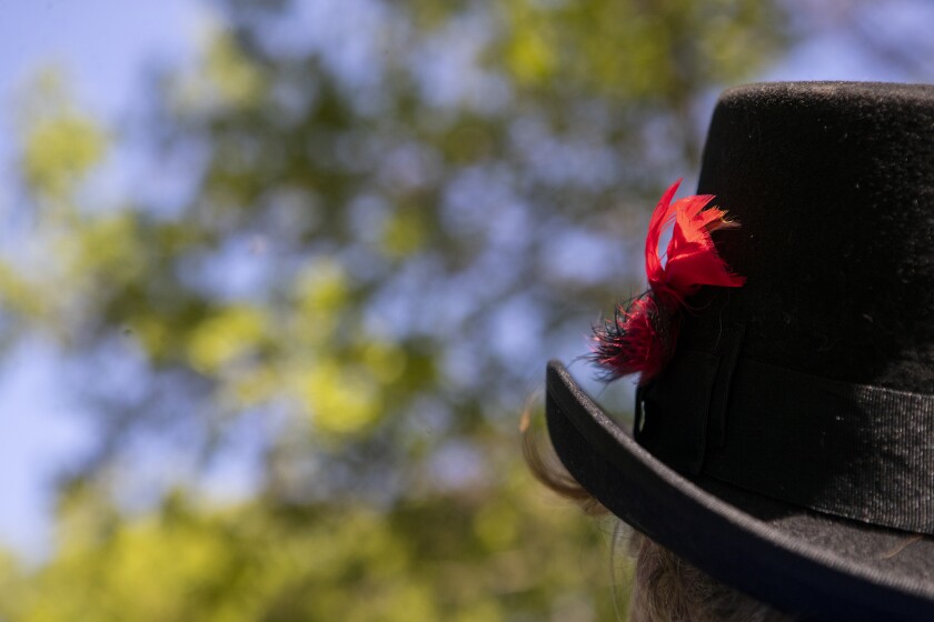 A feather blows in the wind in the cap of Shari Erickson as she gives a carriage ride along the Luce Line State Trail near Cedar Mills in Meeker County on Saturday, May 28, 2022.