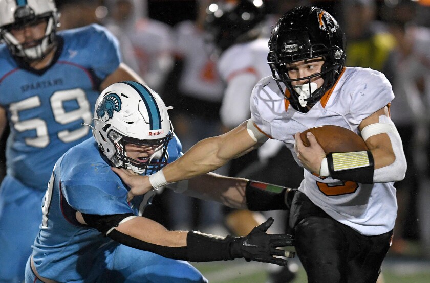 New Richmond’s Andrew Trandahl (5) stiff arms Superior Jack Rivord (19)