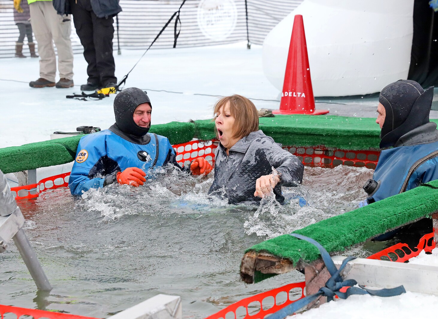 People jump into the water during the Polar Plunge event on Pelican Lake.