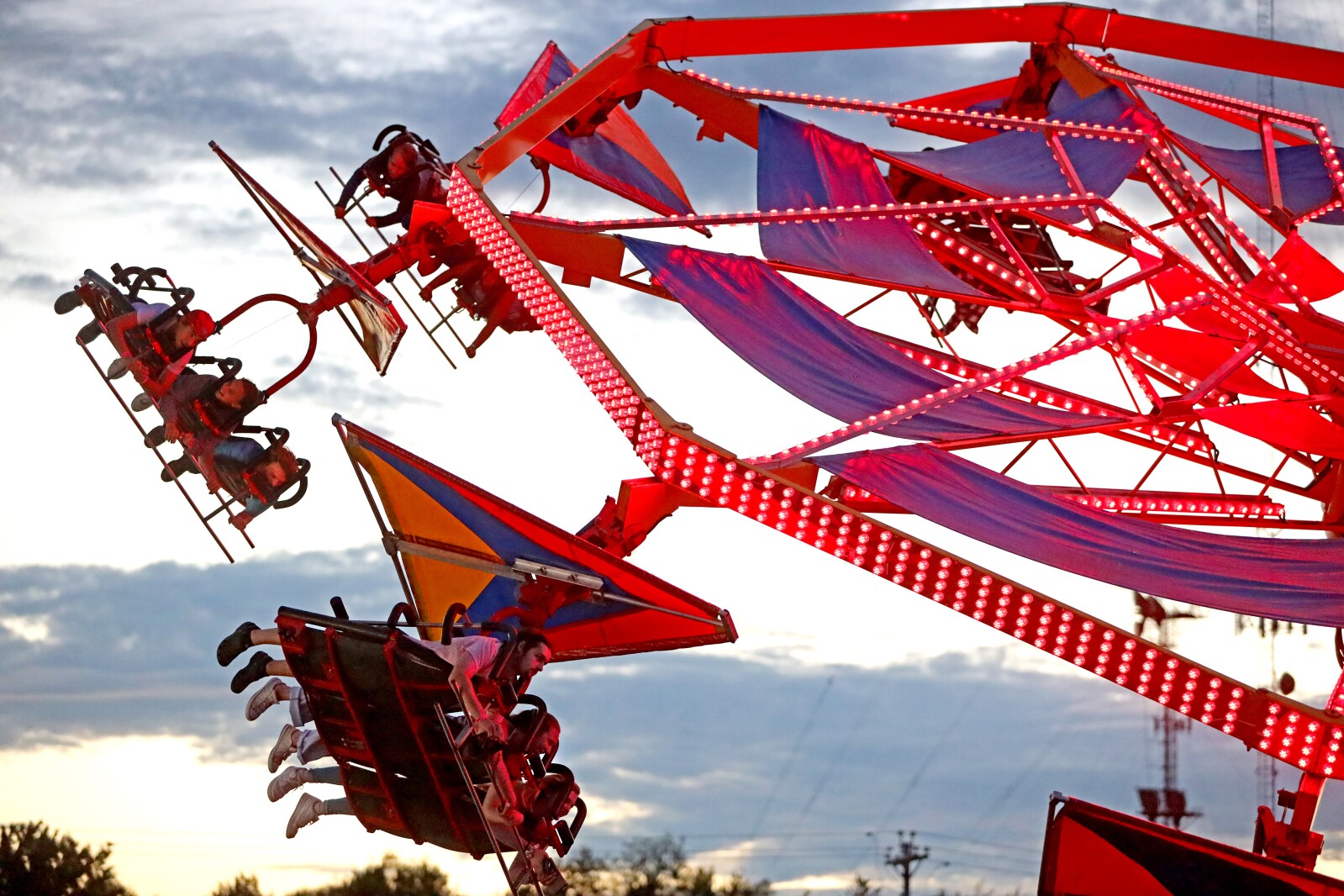 The fair midway ride Soarin' spins people around.