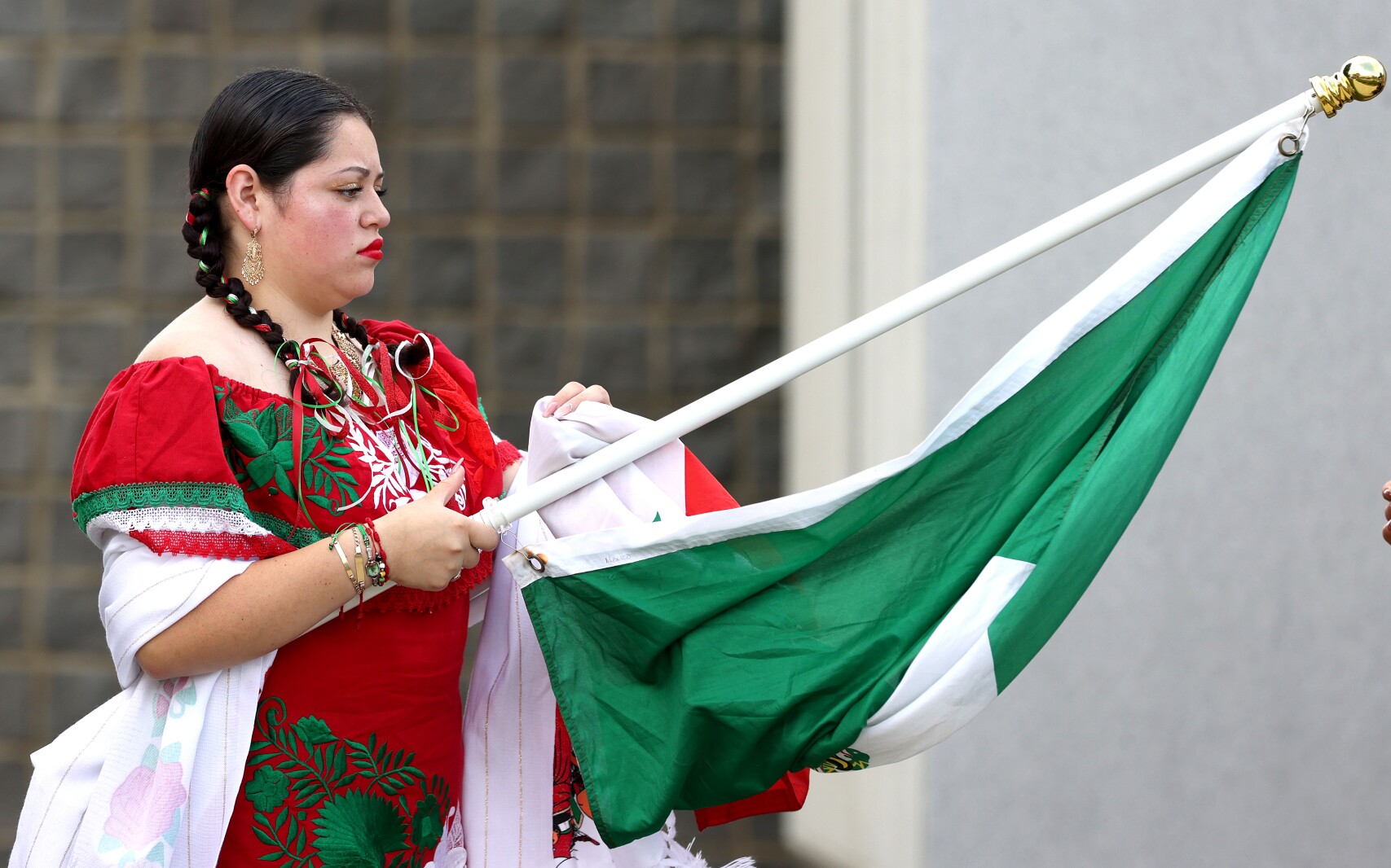 A flag-bearer representing Mexico gets her flag ready for the parade of flags at the opening of the 28th annual Worthington International Festival on Friday, July 8, 2022.
