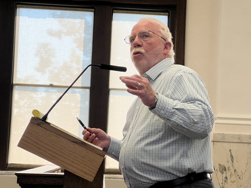 Attorney speaks at a microphone in the Crow Wing County Boardroom