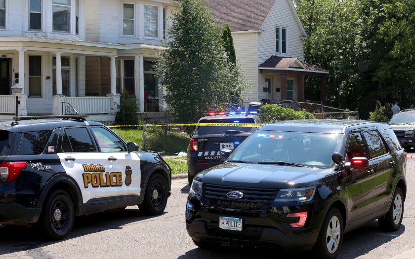 Police squad cars at the scene of a shooting.