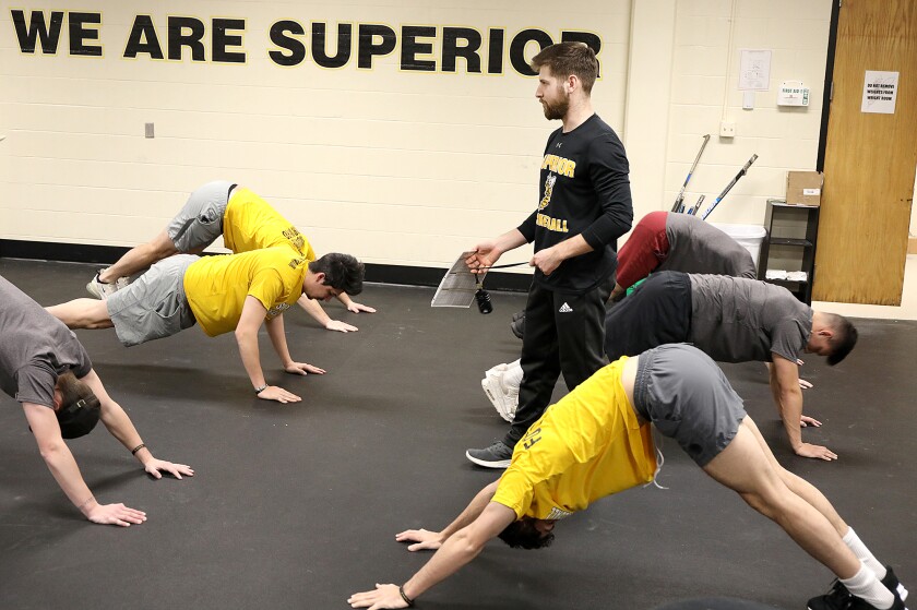 UW-Superior strength and conditioning coach P.J. Piotrowski walks through the baseball team as they stretch