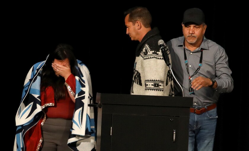 Superior City Councilor Jenny Van Sickle, left, is overcome with emotion after being wrapped in a shawl by Thomas Howes, center, Fond du Lac Natural Resources Manager, and Kevin Dupuis, the Chair of the Fond du Lac Band of Lake Superior Ojibwe, during the Reclamation Ceremony