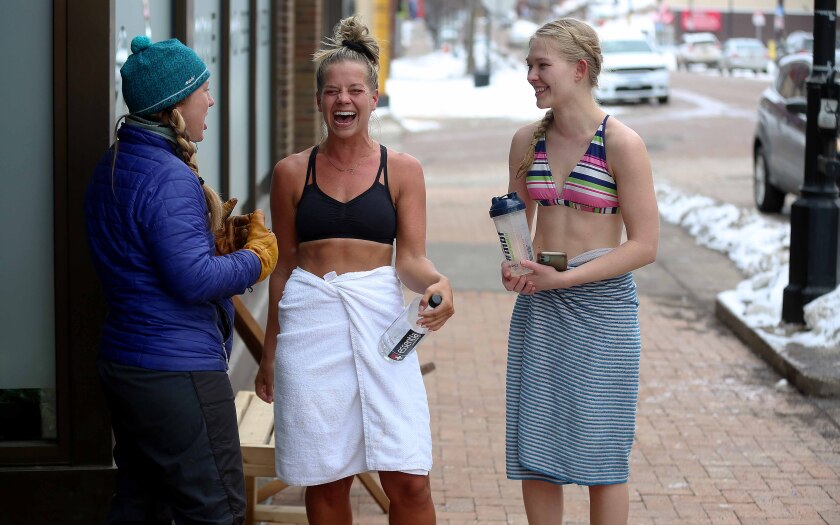 Three women laughing while standing outside