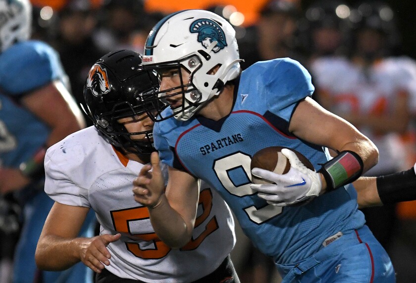 Superior quarterback Carson Gotelaere (9) scrambles from New Richmond’s Caleb Hyman (52)