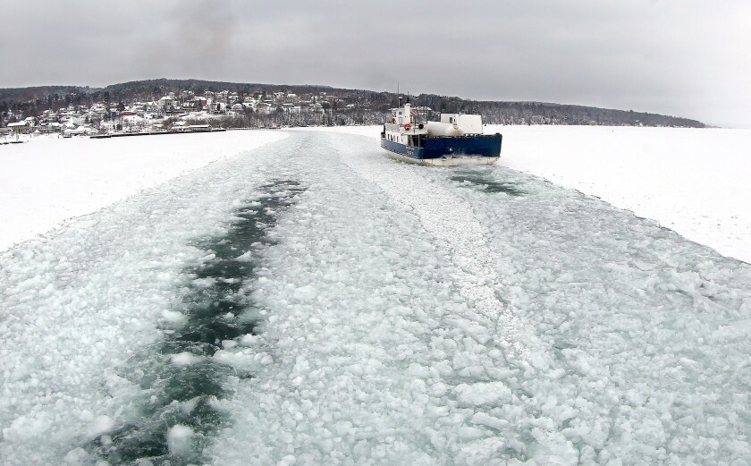 Under low clouds, the Island Queen ferry travels a channel filled with ice churned by it and the Nichevo II's runs to and from Madeline Island on Friday. Bob King / rking@duluthnews.com