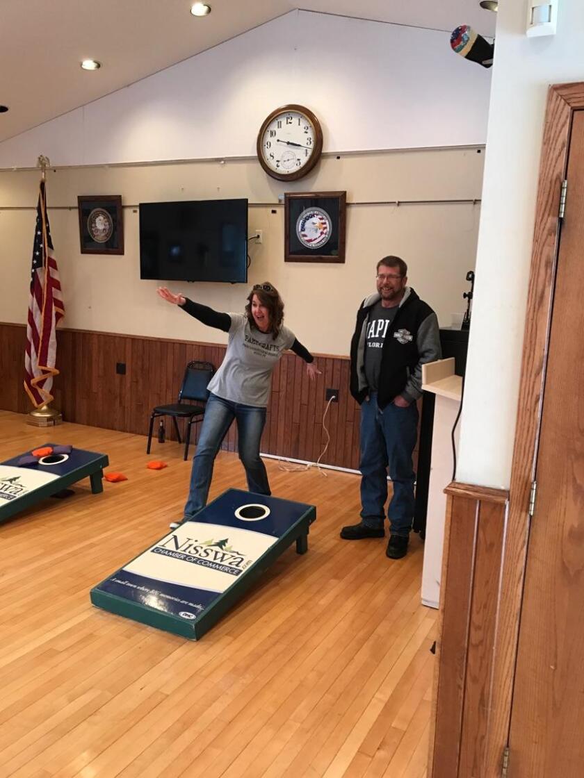 A woman throws her hands up in the air at the Nisswa American Legion bean bag tourney that is part of the Nisswa Winter Jubilee.