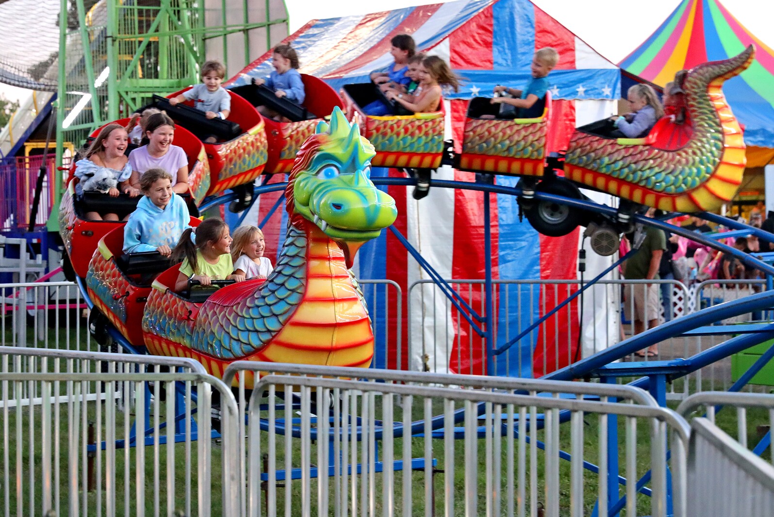 Kids ride a dragon roller coaster at the fair
