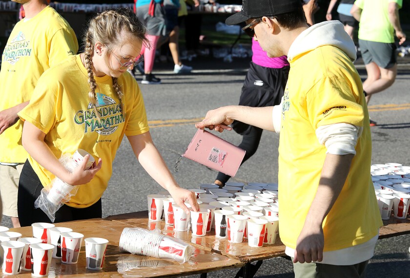 Megan Matheson, left, sets out cups as Cory Kovak fills them with water as the two Duluthians volunteer along London Road