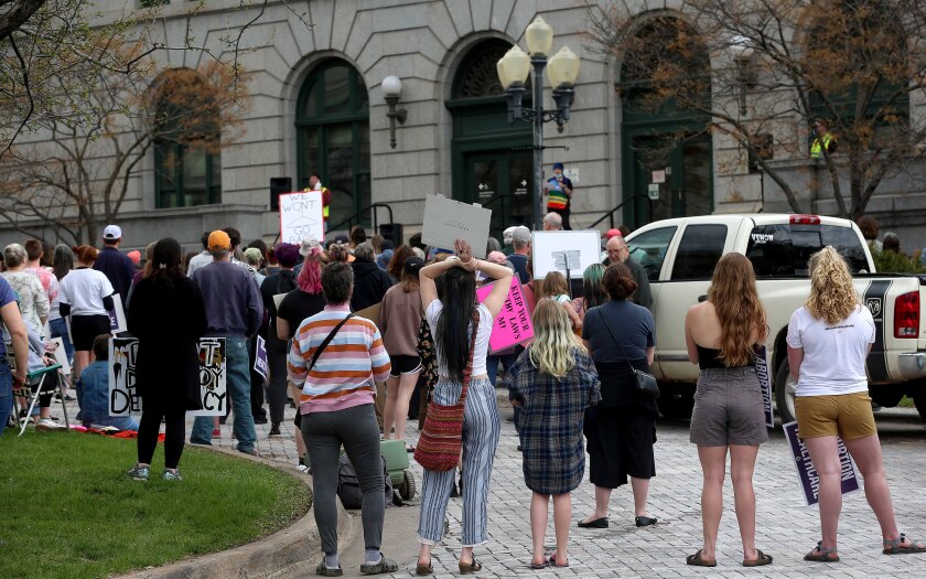 People gathered for a protest listen to a speaker