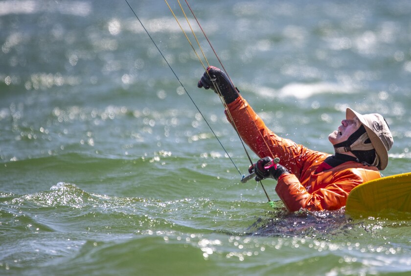 Jerry Sandell of South Haven powers up his kite and straightens the lines before kitesurfing along Green Lake outside Spicer on Saturday May 7, 2022.