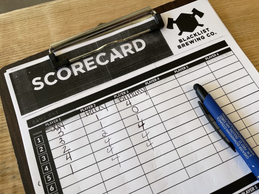 Scorecard with Blacklist Brewing logo, and single-digit scores by round accorded to three players including Jay