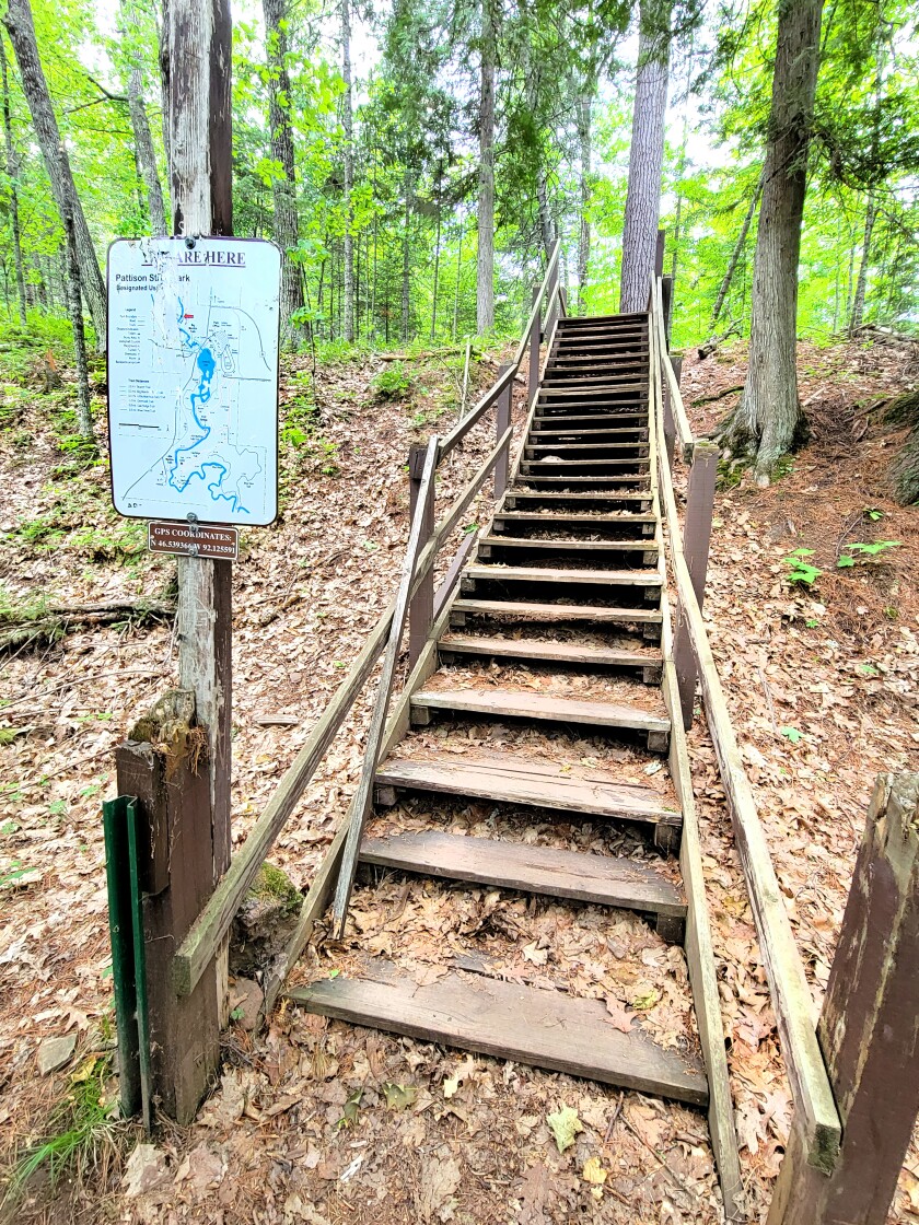 A set of weathered stairs leads visitors to the Black River on the Big Manitou Falls River Trail on June 26, 2022.