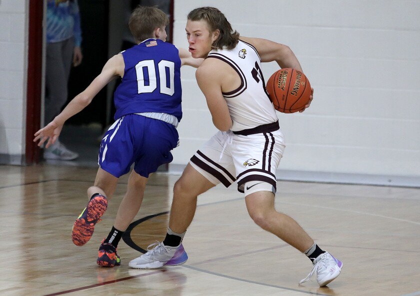 Solon Springs’ Abe Ahlberg (21) swipes the ball from Mellen’s Brysen Stricker (00)