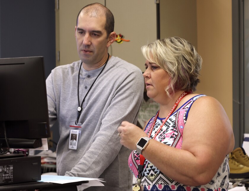Man and woman working on a computer.