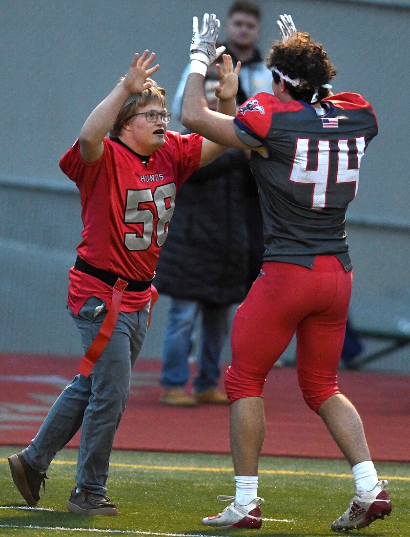 Duluth East’s William Hassebrock (58) is congratulated by fellow Greyhound Charles Sutherland (44) after Hassebrock’s touchdown