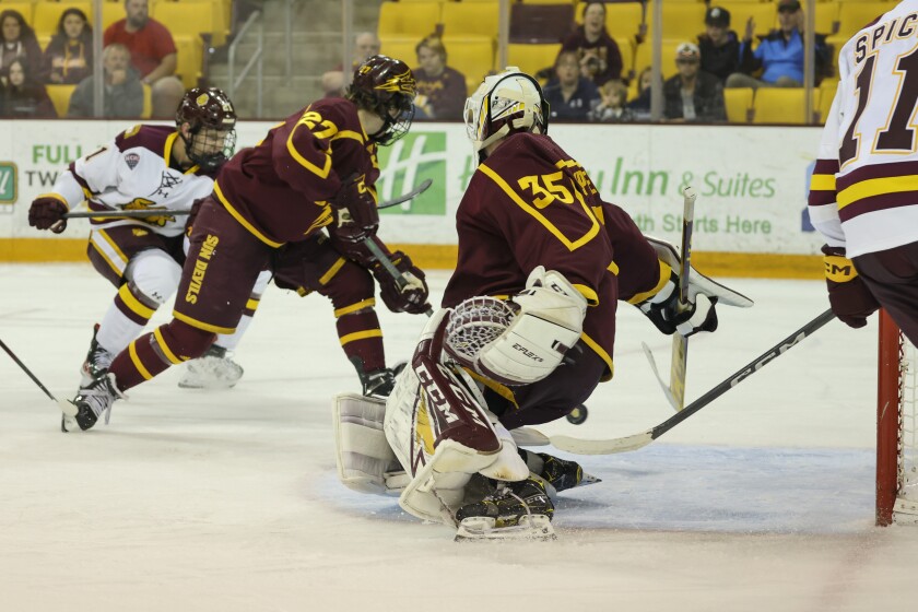 College hockey players play game in indoor arena