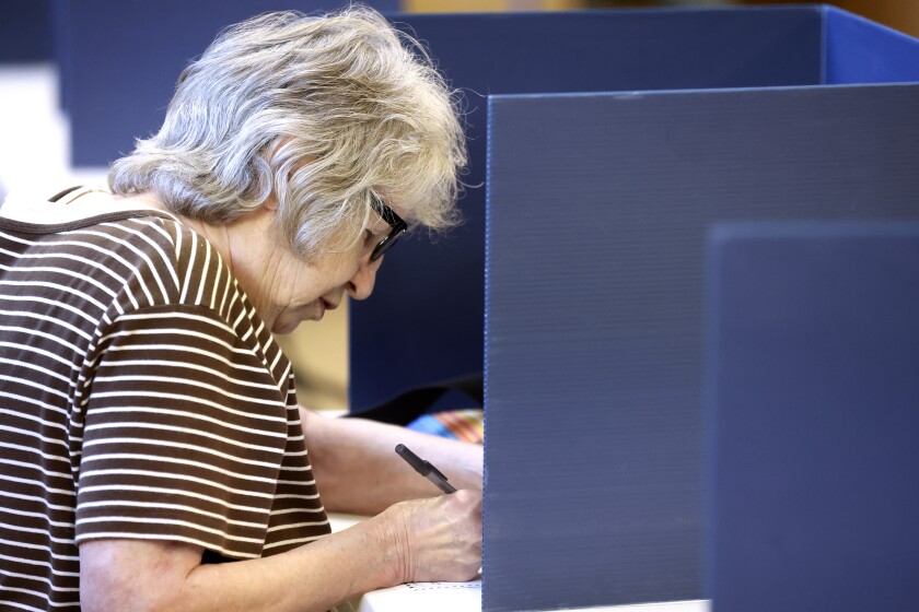 A woman fills out her ballot.