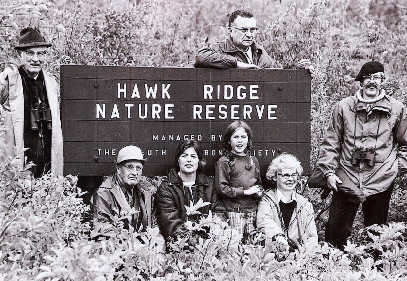People and Hawk Ridge wooden sign