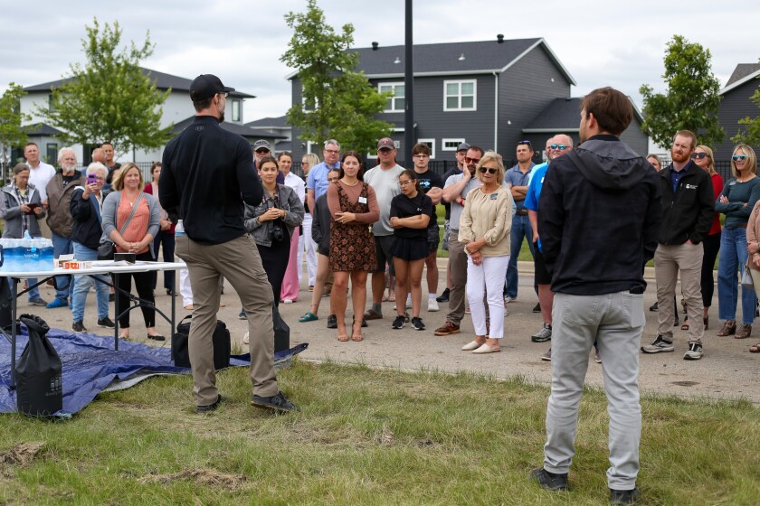 Jake Haile, on the left facing the crowd, the owner of CrossFit Fargo and the founder of the Fargo Fitness Project, talks with people before a groundbreaking ceremony on the site of the facility in south Fargo on Wednesday, June 25, 2025.