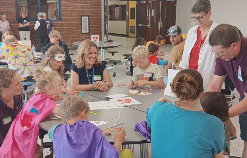Children and parents make friendship bracelets and "heart-o-meter" crafts at the third "Grow a Heart" session on Thursday, July 10, 2025.