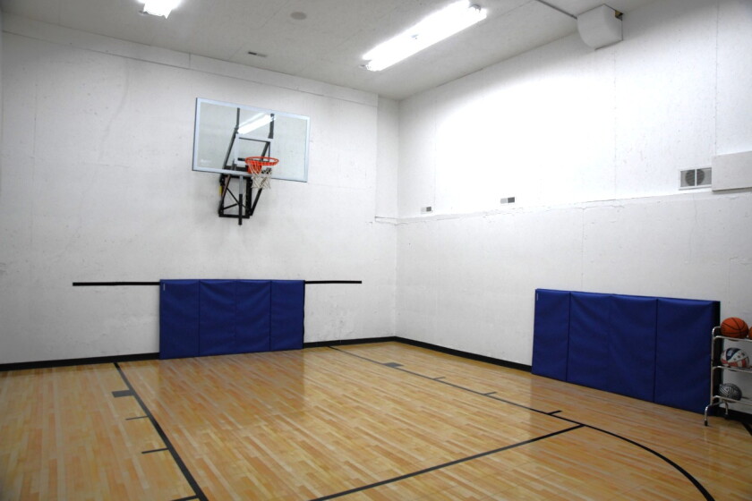 A basketball court sits in the basement of a home.