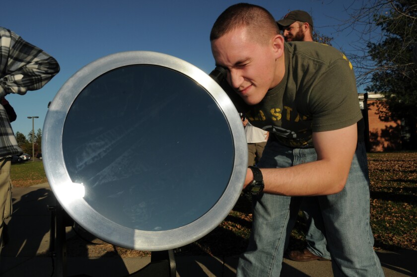 Member of Dave Kobilka’s Astronomy Class and potential member of the Astronomy Club, Josh Schultz watches the partial solar eclipse through a telescope on the Brainerd Campus of Central Lakes College Thursday. An array of telescopes were all pointing to the western sky outside of the college as the moon began to obscure the sun as we see it in Brainerd. Brainerd Dispatch/Steve Kohls