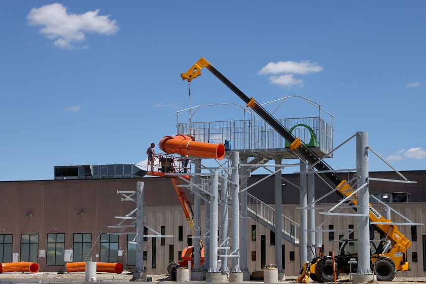 A construction crew assembles a slide at the new City of Worthington aquatic center, located next to the Worthington Area YMCA Wednesday afternoon, June 22, 2022.