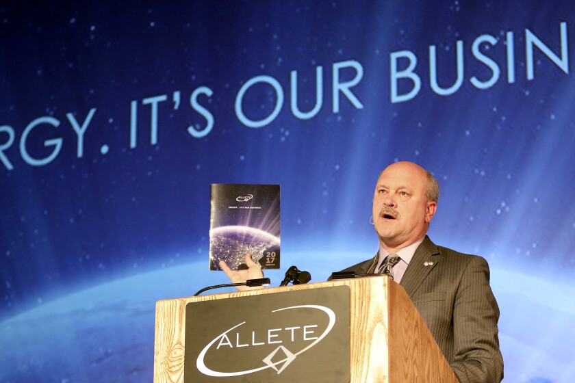 Al Hodnik, chairman, president and CEO of Allete, holds a copy of the company’s 2017 profile while addressing shareholders at Tuesday’s annual investors conference in Duluth. Steve Kuchera / skuchera@duluthnews.com
